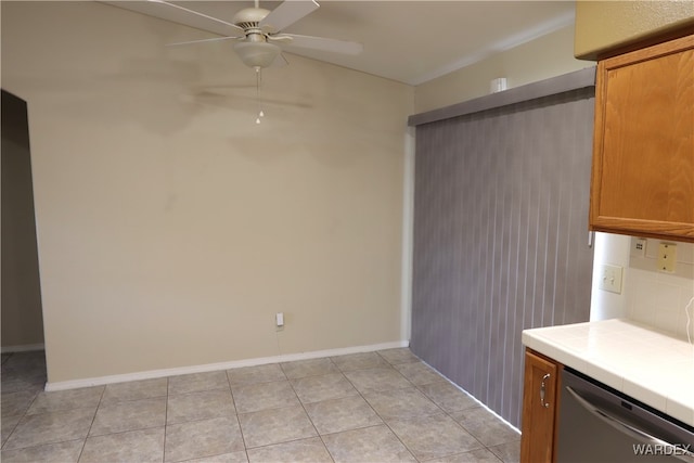 kitchen with decorative backsplash, brown cabinets, tile countertops, and stainless steel dishwasher