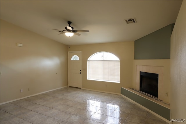 entrance foyer with a ceiling fan, a tiled fireplace, visible vents, and baseboards