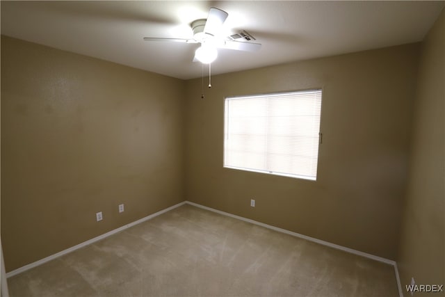 unfurnished room with light carpet, a ceiling fan, visible vents, and baseboards