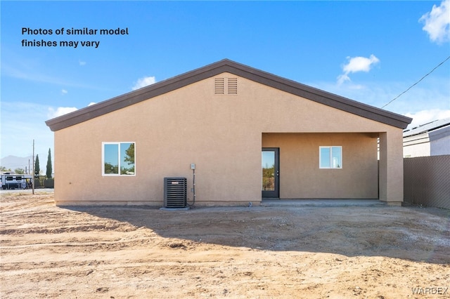 back of property featuring central air condition unit, fence, and stucco siding