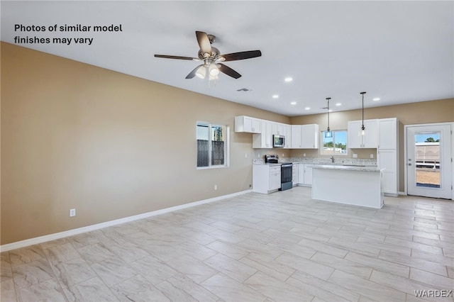 kitchen with a center island, decorative light fixtures, appliances with stainless steel finishes, a healthy amount of sunlight, and white cabinetry