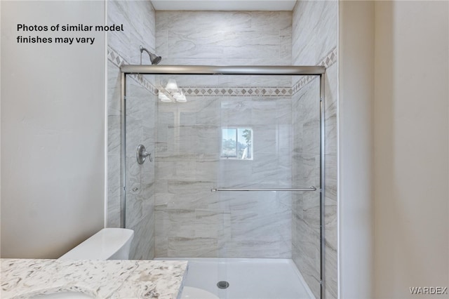 bathroom featuring a stall shower, vanity, and toilet