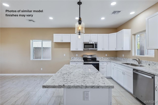 kitchen featuring pendant lighting, appliances with stainless steel finishes, a center island, and white cabinets