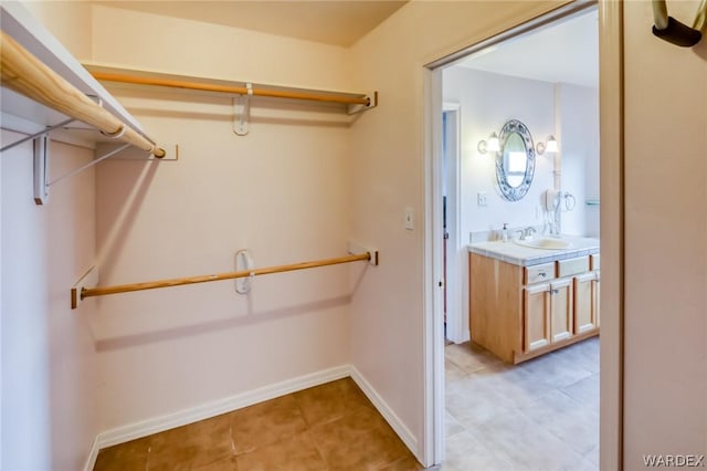 spacious closet with light tile patterned flooring and a sink