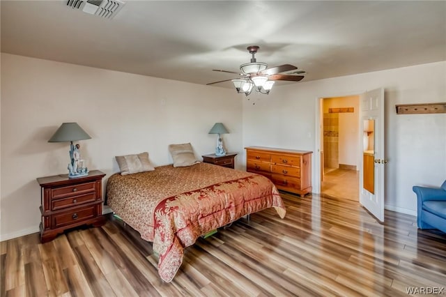 bedroom featuring ceiling fan, wood finished floors, visible vents, and baseboards