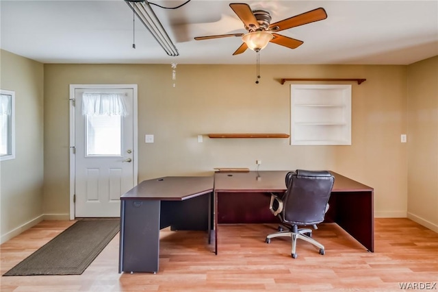 home office featuring baseboards, ceiling fan, and light wood finished floors