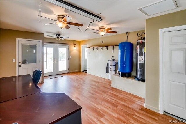 interior space featuring water heater, french doors, wood finished floors, and baseboards