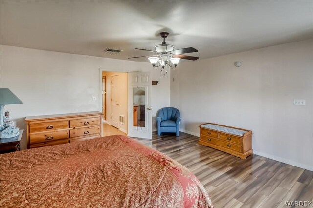 bedroom with a ceiling fan, baseboards, visible vents, and dark wood-type flooring