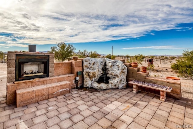 view of patio with an outdoor stone fireplace