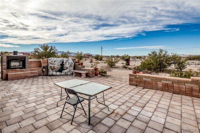 view of patio / terrace with an outdoor stone fireplace