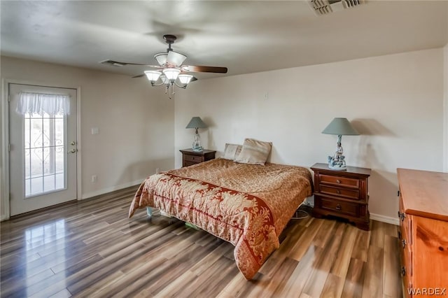 bedroom featuring wood finished floors, visible vents, and baseboards