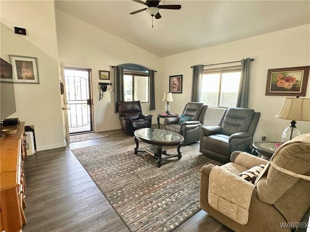 living area featuring vaulted ceiling, dark wood-type flooring, a ceiling fan, and baseboards