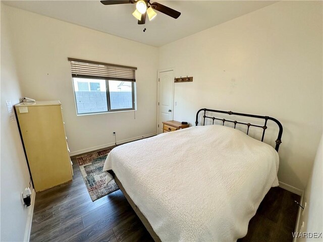 bedroom with a ceiling fan, dark wood-style flooring, and baseboards