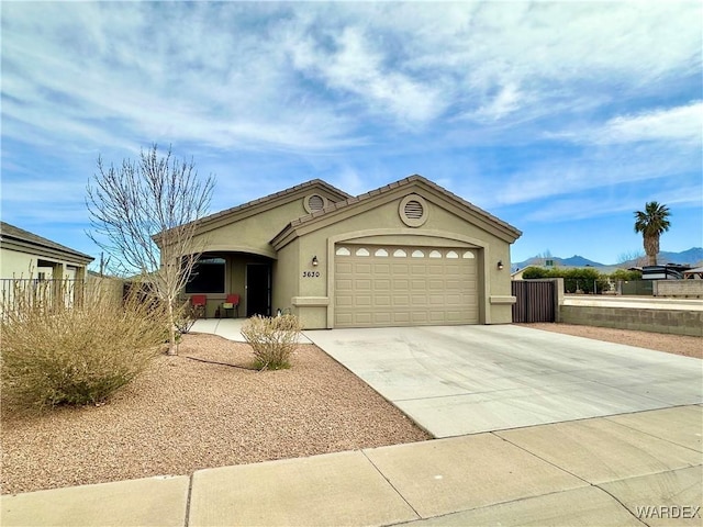 view of front facade with an attached garage, concrete driveway, and stucco siding