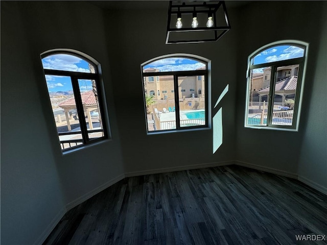 empty room with dark wood-style floors and baseboards