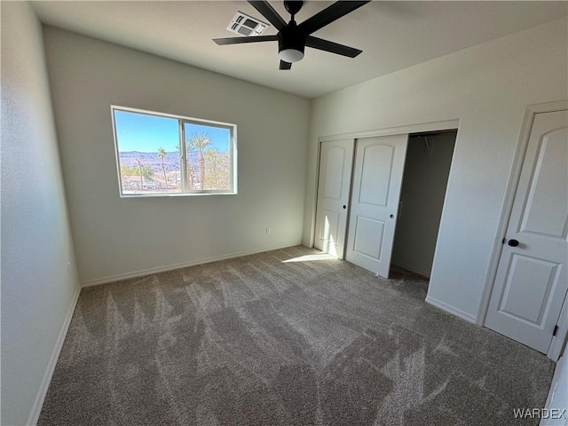 unfurnished bedroom with ceiling fan, visible vents, baseboards, a closet, and dark colored carpet