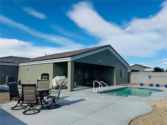 back of house featuring fence, stucco siding, a fenced in pool, a patio area, and central air condition unit