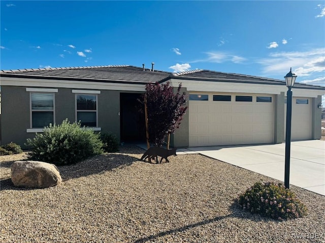 single story home with stucco siding, concrete driveway, a tile roof, and a garage