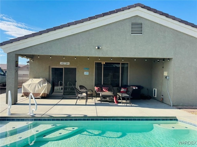 rear view of house with visible vents, stucco siding, outdoor lounge area, an outdoor pool, and a patio area
