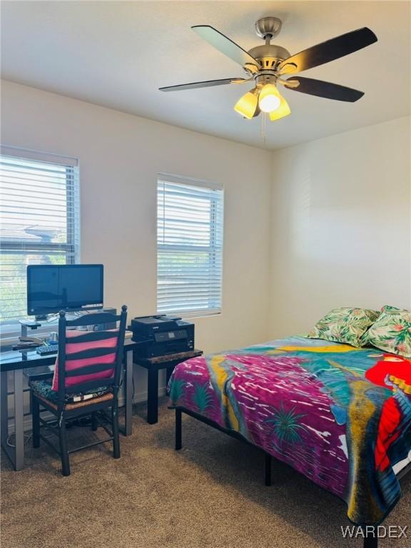 bedroom with carpet floors, ceiling fan, and multiple windows