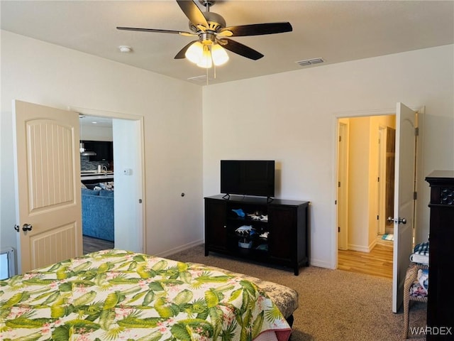 bedroom with baseboards, ceiling fan, carpet flooring, and visible vents