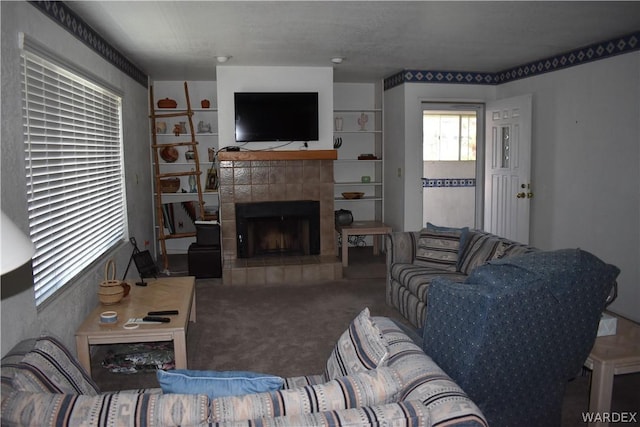 carpeted living room with a tiled fireplace