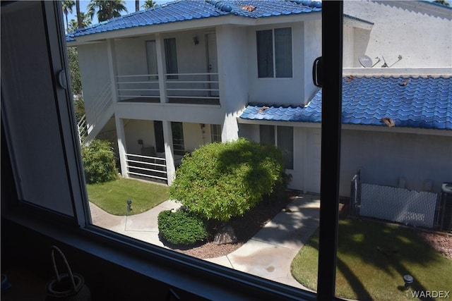 back of property featuring a balcony and stucco siding