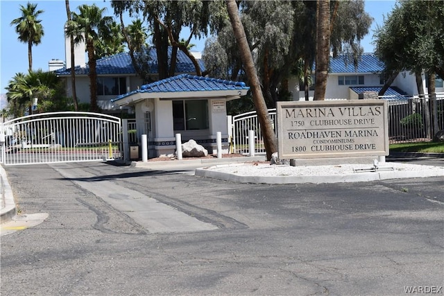 community sign featuring a gate and fence