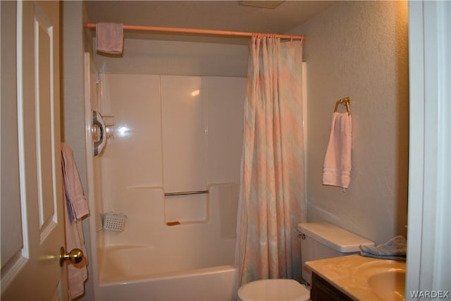 bathroom featuring toilet, a textured wall, shower / tub combo with curtain, and vanity