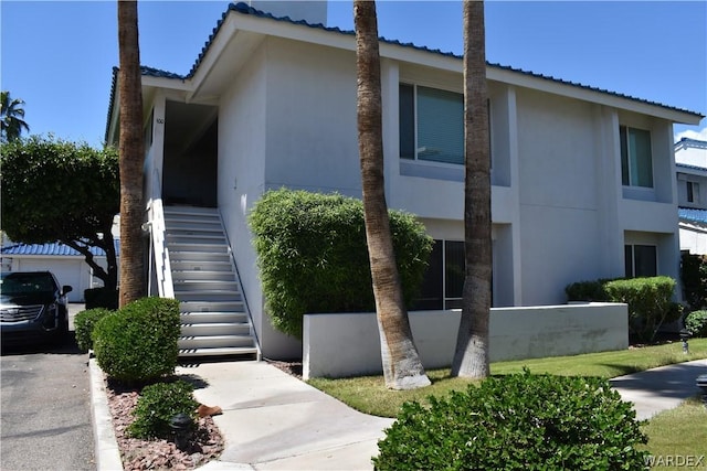 exterior space with stairs and stucco siding