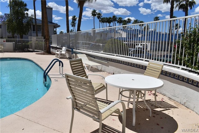 pool with a patio and fence