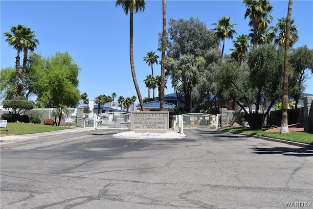 view of street with curbs, a gated entry, and a gate