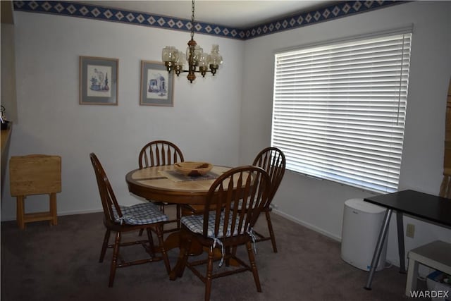 dining room with baseboards, dark colored carpet, and a notable chandelier