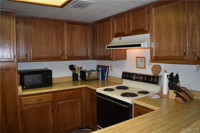 kitchen with electric stove, brown cabinets, light countertops, ventilation hood, and black microwave