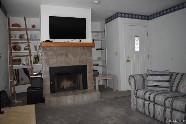 carpeted living room featuring built in shelves and a tile fireplace