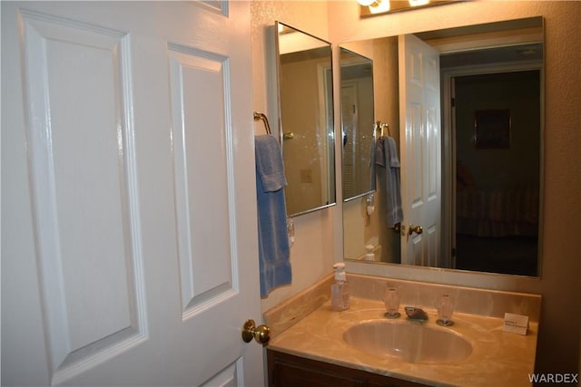 bathroom with a textured wall and vanity