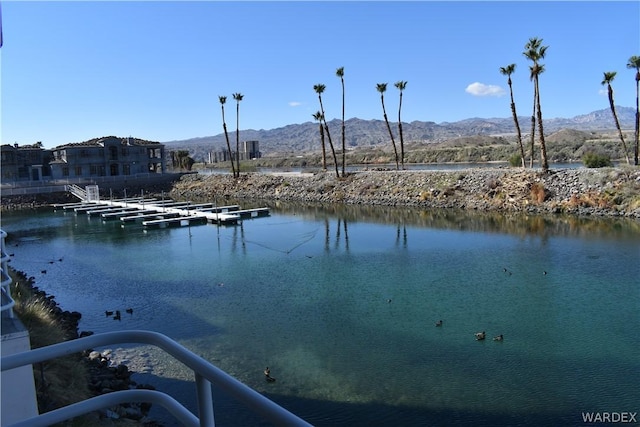 water view with a floating dock and a mountain view