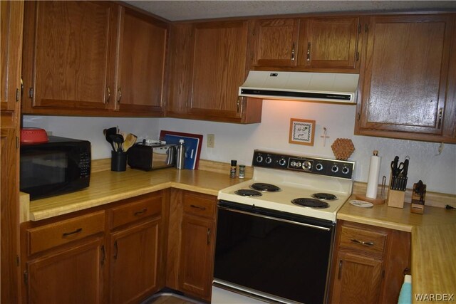 1800 Clubhouse Dr Unit 100, Bullhead City, AZ 86442 - kitchen featuring black microwave, light countertops, range with electric stovetop, and exhaust hood