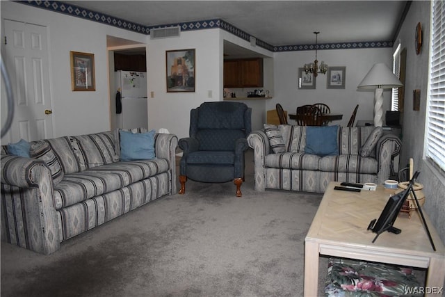 carpeted living area with visible vents and a notable chandelier