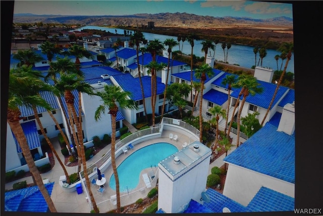 view of pool with a water view, a residential view, and fence