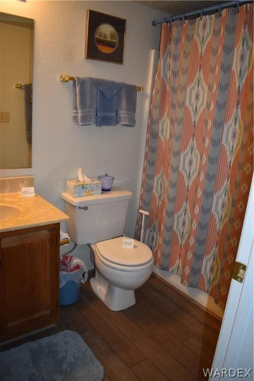 bathroom with a shower with curtain, vanity, toilet, and wood finished floors