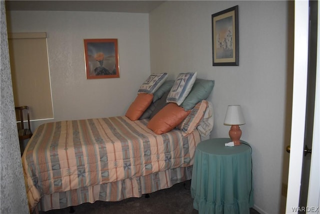 bedroom with dark colored carpet