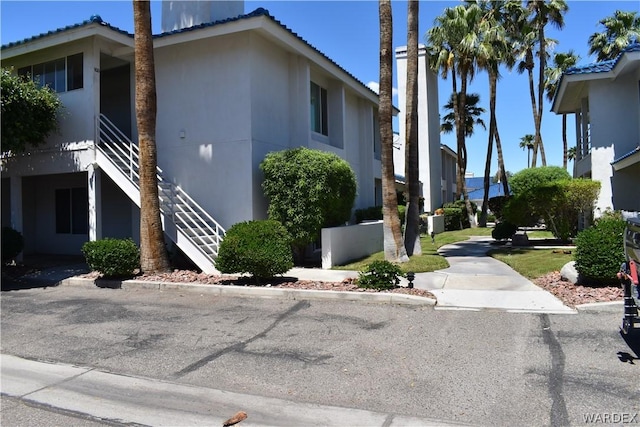 1800 Clubhouse Dr Unit 100, Bullhead City, AZ 86442 - view of property exterior featuring stairway, a tile roof, and stucco siding