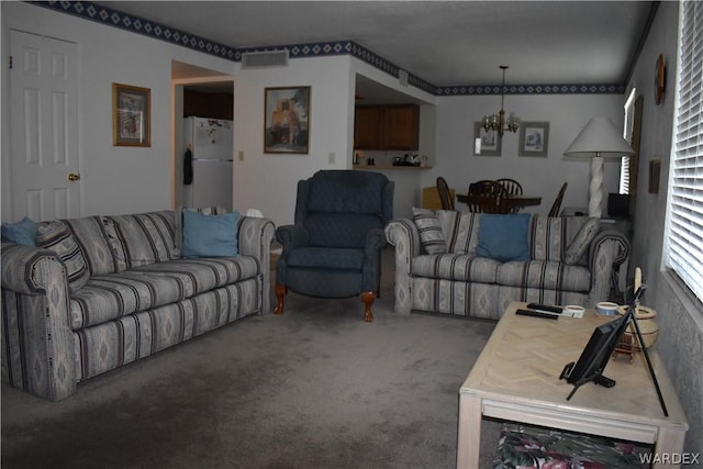 carpeted living area featuring visible vents and a notable chandelier