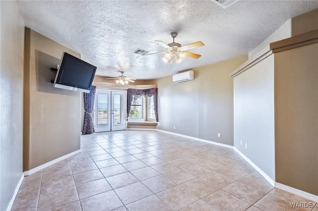 spare room with light tile patterned flooring, a wall mounted AC, baseboards, and visible vents
