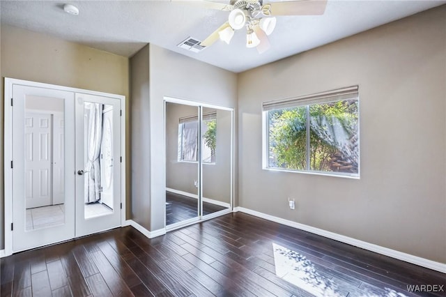unfurnished bedroom featuring wood finished floors, visible vents, and baseboards