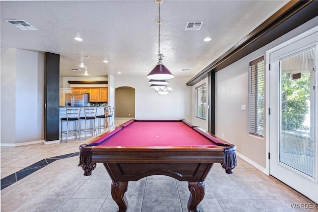 rec room featuring arched walkways, light tile patterned floors, and visible vents