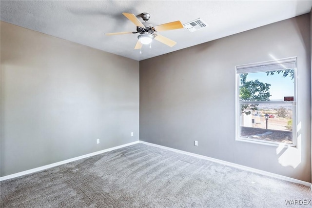 carpeted empty room featuring baseboards, ceiling fan, and visible vents