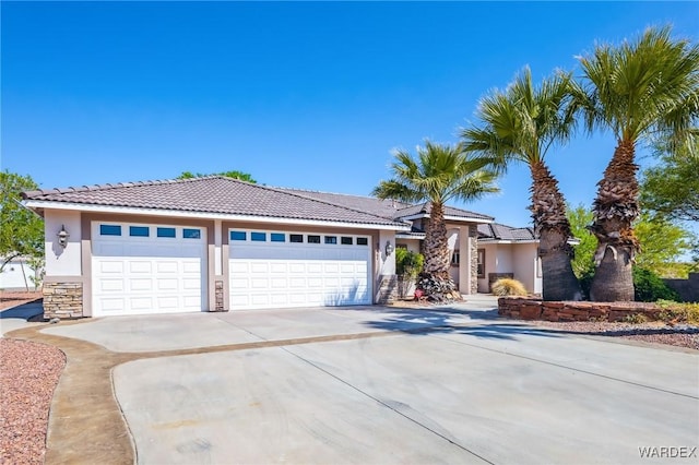 single story home with driveway, a tiled roof, a garage, stucco siding, and stone siding