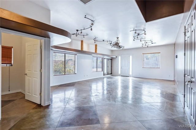 unfurnished living room featuring baseboards and visible vents